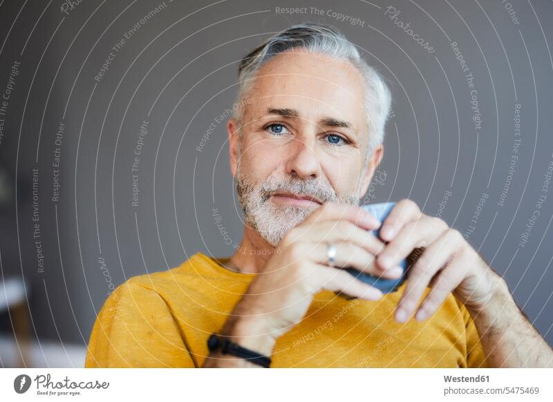 Porträt eines entspannten reifen Mannes zu Hause bei einer Tasse Kaffee Leute Menschen People Person Personen Alleinstehende Alleinstehender Singles