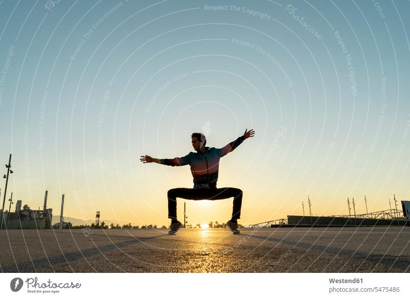 Acrobat macht bei Sonnenaufgang Bewegungstraining in der Stadt Barcelona verspielt spielerisch Asphalt Gelegenheit Möglichkeit Möglichkeiten Breakdance