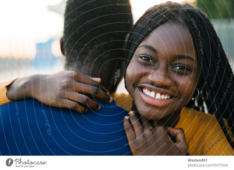Glückliches Teenager-Mädchen umarmt Freund im Freien Farbaufnahme Farbe Farbfoto Farbphoto Außenaufnahme außen draußen Tag Tageslichtaufnahme