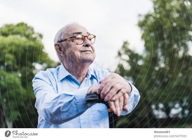 Porträt eines älteren Mannes in einem Park, der sich auf seinen Gehstock stützt Leute Menschen People Person Personen Europäisch Kaukasier kaukasisch 1 Ein