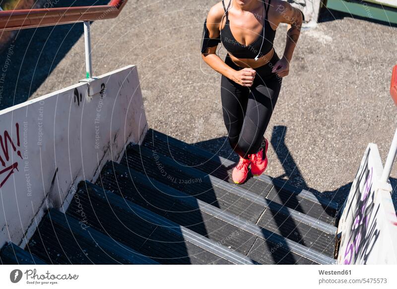 Junge Frau rennt die Treppe hinauf Telekommunikation telefonieren Handies Handys Mobiltelefon Mobiltelefone rennen Jahreszeiten sommerlich Sommerzeit Farben