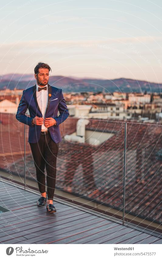 Italien, Florenz, Porträt eines stilvollen Mannes auf der Dachterrasse bei Sonnenuntergang Jackett Anzugjacke gut gekleidet Smart Casual gut angezogen