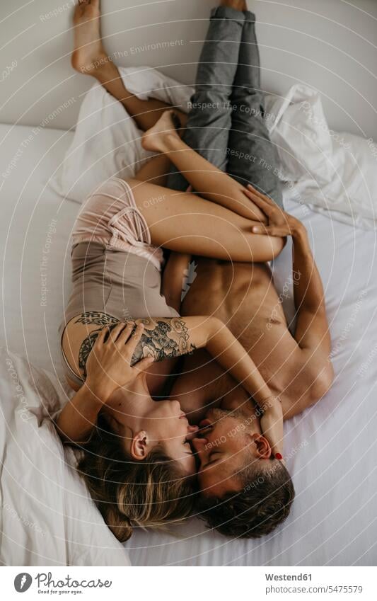 Romantisches junges Paar im Bett liegend Betten romantisch schwärmerisch schwaermerisch gefuehlvoll gefühlvoll Romantik liegt Pärchen Paare Partnerschaft Mensch