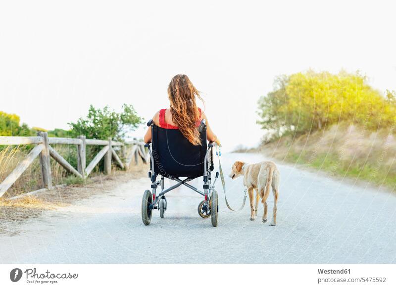 Frau im Rollstuhl mit Hund auf der Straße gegen klaren Himmel Farbaufnahme Farbe Farbfoto Farbphoto Spanien Freizeitbeschäftigung Muße Zeit Zeit haben