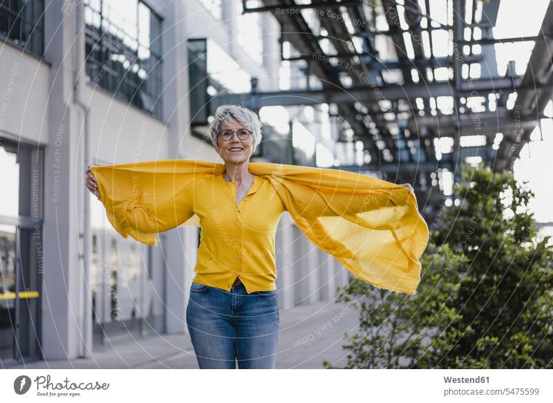 Bildnis einer lächelnden reifen Frau mit gelber Strickjacke und Schal Leute Menschen People Person Personen Alleinstehende Alleinstehender Singles