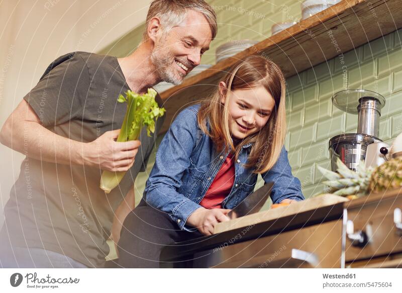 Glückliche Vater und Tochter in der Küche bei der Zubereitung von Gemüse freuen Frohsinn Fröhlichkeit Heiterkeit glücklich sein glücklichsein daheim zu Hause