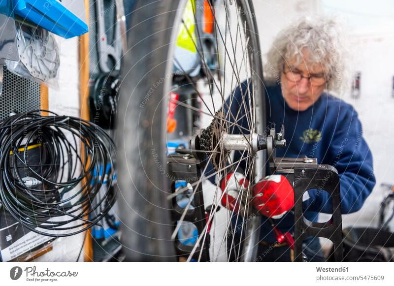 Fahrradmechaniker im Fahrradgeschäft Job Berufe Berufstätigkeit Beschäftigung Jobs Handschuhe Raeder Räder Bike Bikes Fahrräder Rad Brillen Arbeit Reparatur