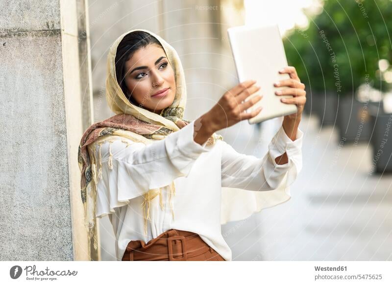 Spanien, Granada, junge muslimische Frau trägt Hijab mit digitalen Tablet-Computer im Freien Kopftuch Kopftücher Moslem Muslim Islam weiblich Frauen
