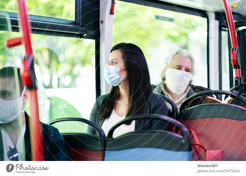 Frau mit Schutzmaske sitzt im Bus und schaut aus dem Fenster, Spanien Transport Transportwesen KFZ Verkehrsmittel Autobus Autobusse Busse Omnibus Omnibusse