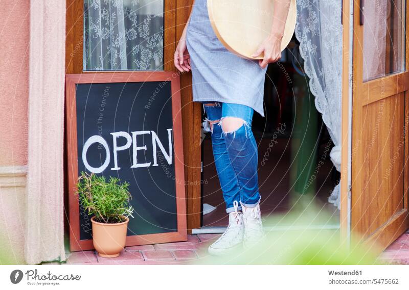 Frau steht an offener Tür eines Cafés auf geöffnet Türen weiblich Frauen stehen stehend Cafe Kaffeehaus Bistro Cafes Kaffeehäuser Erwachsener erwachsen Mensch