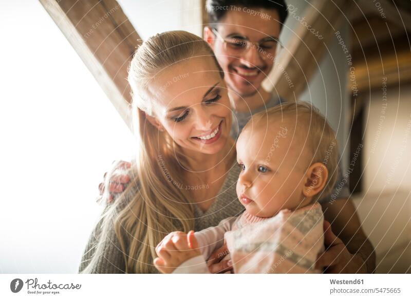 Glückliche junge Eltern, die Zeit zu Hause mit ihrem kleinen Mädchen verbringen Zuhause daheim Familie Familien Baby Babies Babys Säuglinge Kind Kinder
