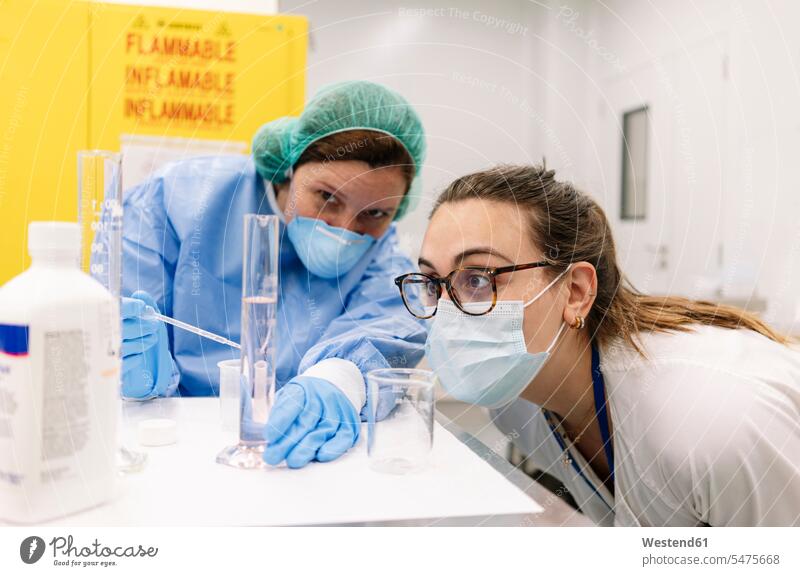 Apothekerinnen untersuchen Chemikalie in Messzylindern im Labor Farbaufnahme Farbe Farbfoto Farbphoto Spanien Innenaufnahme Innenaufnahmen drinnen Medizin