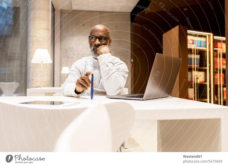 Porträt eines nachdenklichen Mannes, der abends in der Bibliothek sitzt Geschäftsmann Businessmann Businessmänner Geschäftsmänner Abend sitzen sitzend Männer