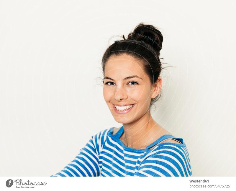 Schöne junge Frau mit schwarzen Haaren und blau-weiß gestreiften Pullover ist vor dem weißen Hintergrund posiert Europäer Kaukasier Europäisch kaukasisch