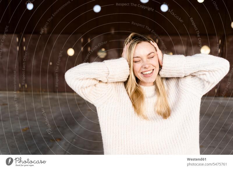 Porträt einer lachenden jungen Frau mit geschlossenen Augen im Freien Muße Lifestyles Spass spassig spaßig Spässe Späße Attraktivität gut aussehend gutaussehend