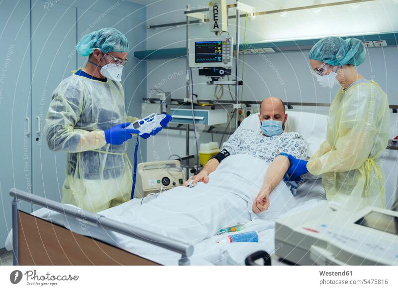 Ärzte, die Patienten auf der Notfallstation eines Krankenhauses betreuen Arbeitskollege Arbeitskollegen Kollege Gesundheit Gesundheitswesen medizinisch
