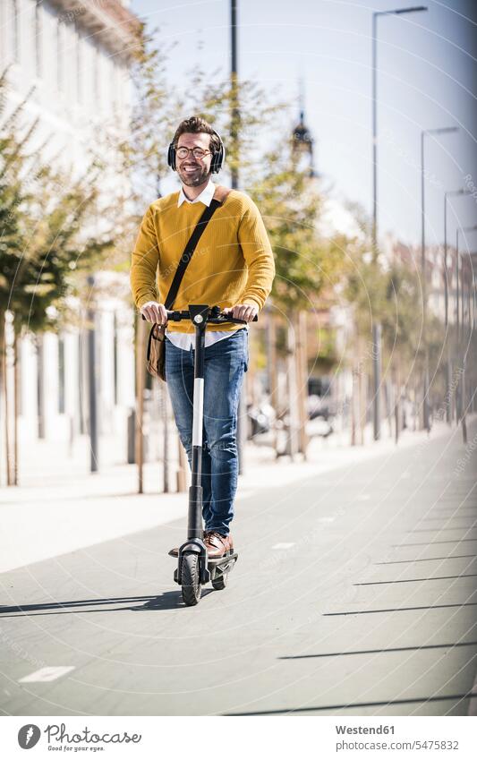 Junger Mann fährt E-Scooter in der Stadt Touristen geschäftlich Geschäftsleben Geschäftswelt Geschäftsperson Geschäftspersonen Businessmann Businessmänner