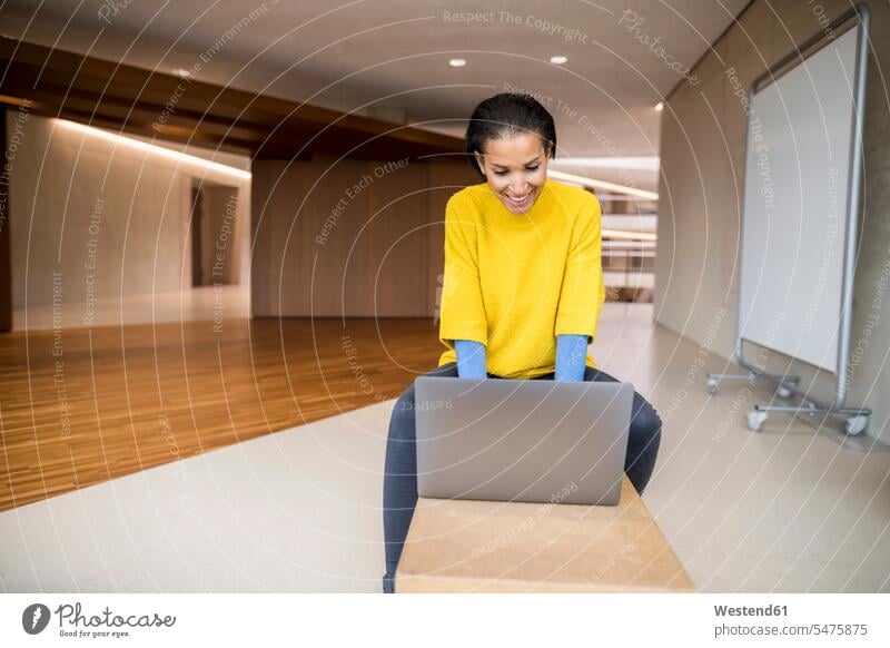 Lachende junge Frau benutzt Laptop an der Universität benutzen lachen Erwachsener Mensch Computer positiv Emotion emotional Laptop benutzen WLan