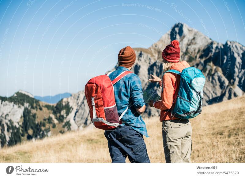 Österreich, Tirol, Paar mit Karte beim Wandern in den Bergen Pärchen Paare Partnerschaft wandern Wanderung Karten Gebirge Berglandschaft Gebirgslandschaft