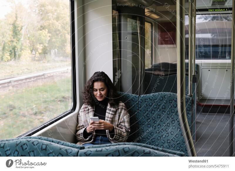 Junge Frau mit Smartphone in der U-Bahn Fensterscheiben Informationen Transport Transportwesen Bahnen Subway U-Bahnen Ubahn Ubahnen Underground Untergrundbahn