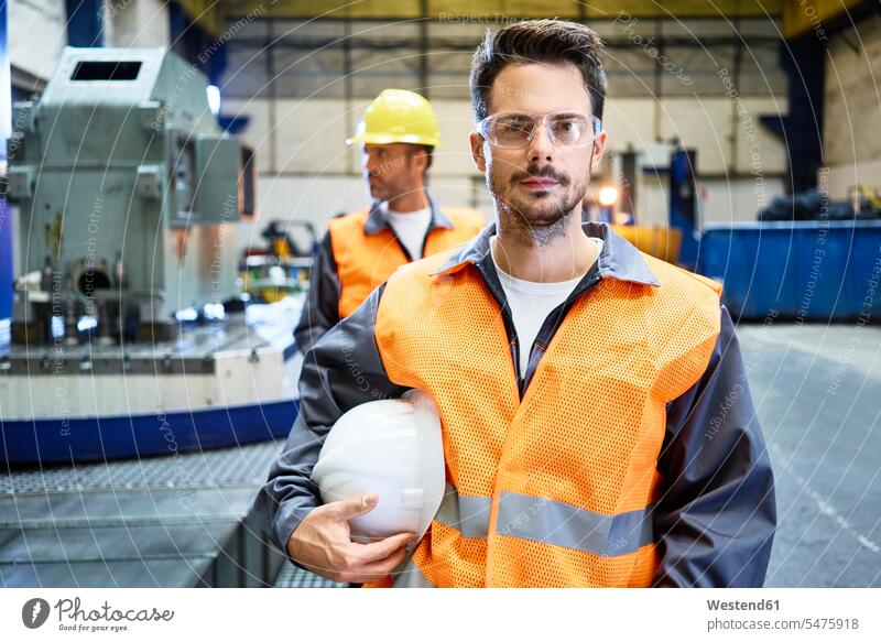 Porträt eines seriösen Mannes mit Arbeitsschutzkleidung in einer Fabrik ernst Ernst Ernsthaftigkeit ernsthaft Fabrikgebäude Fabrikgebaeude Fabriken