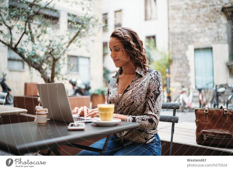 Junge Frau mit Laptop in einem Straßencafé Job Berufe Berufstätigkeit Beschäftigung Jobs geschäftlich Geschäftsleben Geschäftswelt Geschäftsperson