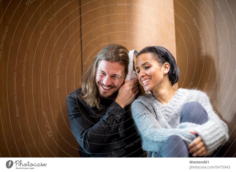 Porträt eines glücklichen Paares beim Musikhören mit Kopfhörern Kopfhoerer hoeren Pärchen Partnerschaft Glück glücklich sein glücklichsein Mensch Menschen Leute
