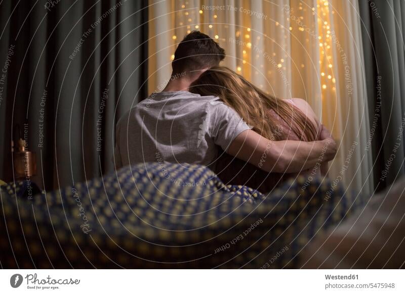 Romantisches junges Paar im Bett sitzend Betten sitzt romantisch schwärmerisch schwaermerisch gefuehlvoll gefühlvoll Romantik Pärchen Paare Partnerschaft Mensch