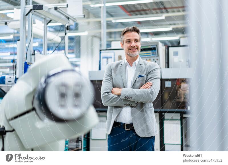 Porträt eines selbstbewussten Geschäftsmannes am Montageroboter in einer Fabrik Job Berufe Berufstätigkeit Beschäftigung Jobs geschäftlich Geschäftsleben