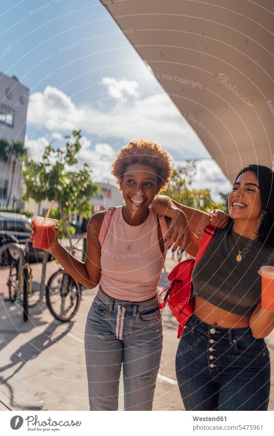 USA, Florida, Miami Beach, zwei glückliche Freundinnen bei einem Softdrink in der Stadt staedtisch städtisch Glück glücklich sein glücklichsein