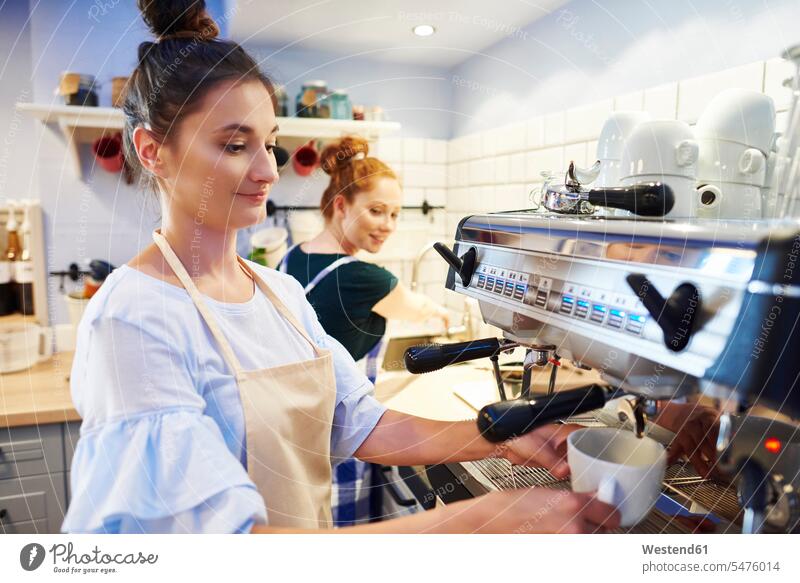 Weibliche Barista macht Kaffee in einem Café Baristas Cafe Kaffeehaus Bistro Cafes Cafés Kaffeehäuser Kaffeemaschine Kaffeemaschinen arbeiten Arbeit Frau
