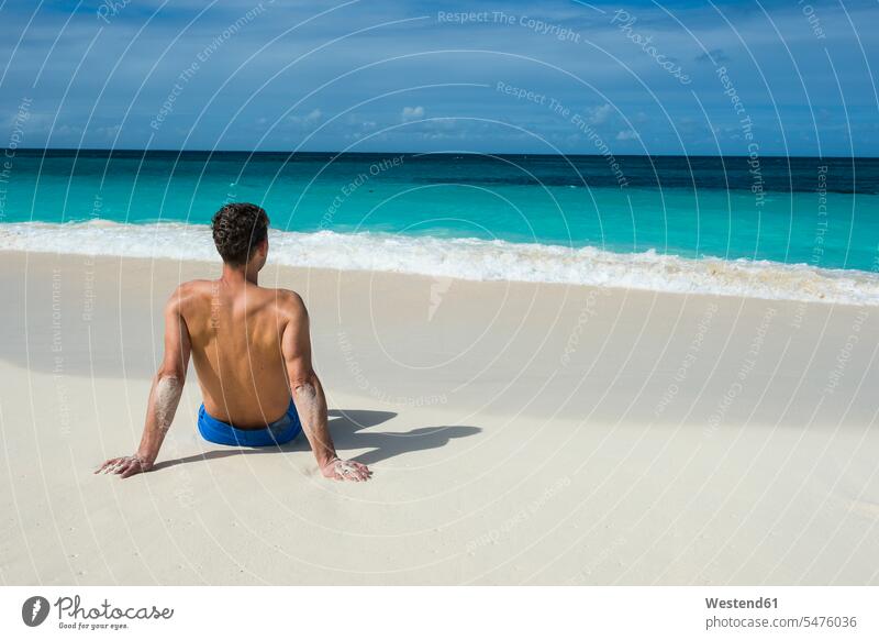 Karibik, Anguilla, Mann sitzt am Strand, Rückansicht erholen erholend In die Ferne sehen Blick in die Ferne Fernblick Traumstrand Traumstrände Traumstraende