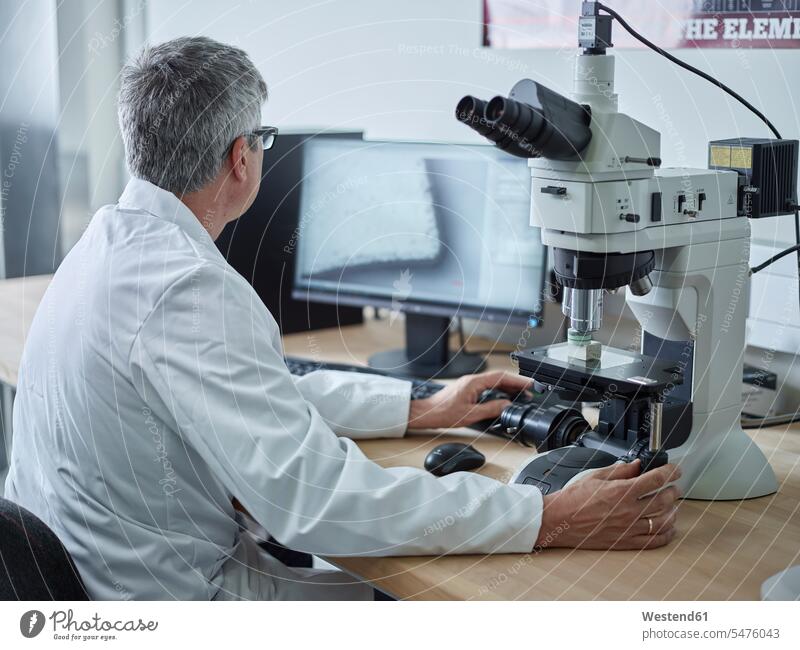 Arzt, der mit dem Mikroskop arbeitet und auf den Bildschirm schaut Labor Labore Mikroskope untersuchen prüfen Laborant Laboranten Arbeitsplatz Arbeitsstätte