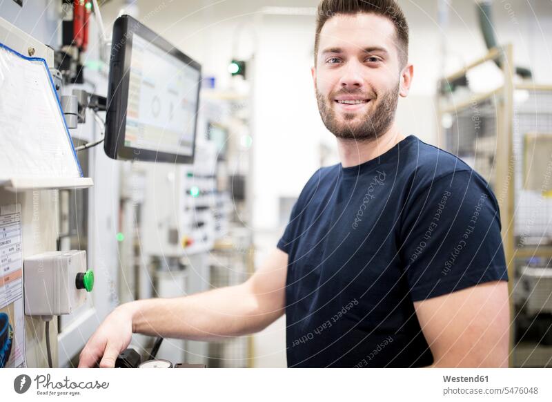 Porträt eines selbstbewussten Mannes, der in einer modernen Fabrik an einer Maschine arbeitet Job Berufe Berufstätigkeit Beschäftigung Jobs Arbeiter T-Shirts