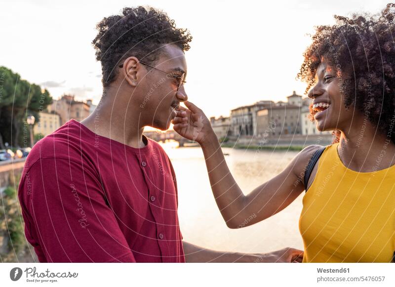 Glückliches junges Touristenpaar am Arno bei Sonnenuntergang, Florenz, Italien Leute Menschen People Person Personen Afrikanisch Afrikanische Abstammung