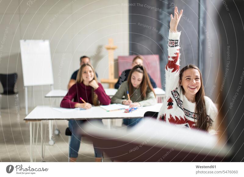 Lächelndes Teenager-Mädchen hebt die Hand in der Klasse melden sich melden Jugendliche Heranwachsende Pubertierende lächeln Schulklasse Schule Schulen