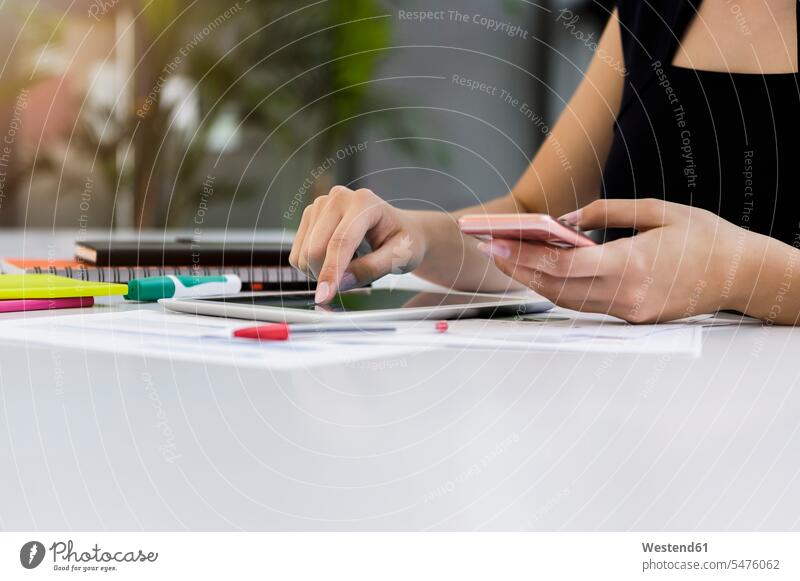 Nahaufnahme einer Geschäftsfrau mit digitalem Tablet und Smartphone auf dem Schreibtisch im Büro Farbaufnahme Farbe Farbfoto Farbphoto Deutschland Innenaufnahme