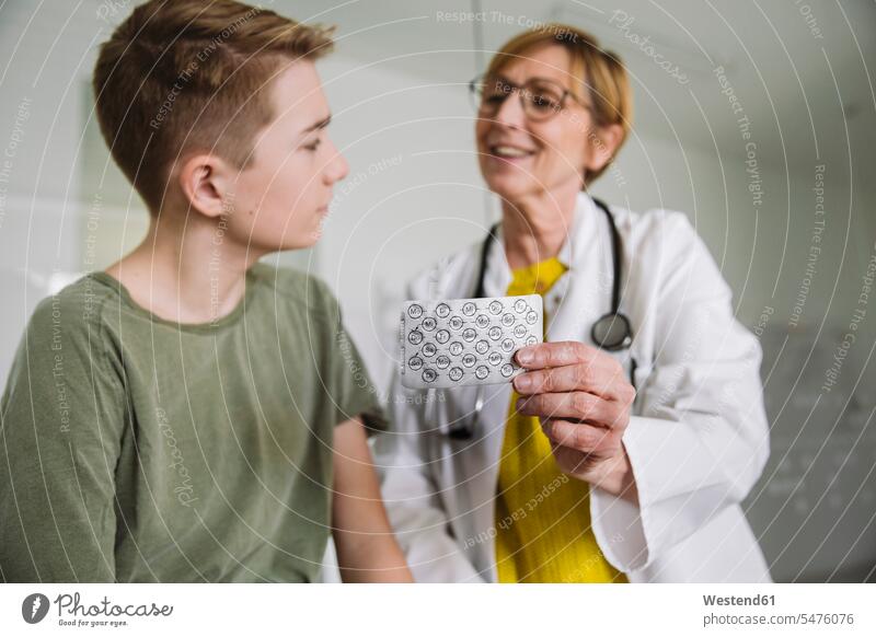 Arzt erklärt Teenager-Jungen in medizinischer Praxis Medikamente Gesundheit Gesundheitswesen Erkrankung Erkrankungen Krankheiten Kranke Kranker Patienten Job