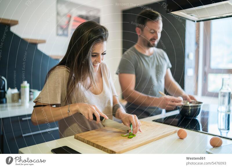 Ehepaar, das zu Hause auf einer Kücheninsel Essen zubereitet Farbaufnahme Farbe Farbfoto Farbphoto Spanien Innenaufnahme Innenaufnahmen innen drinnen