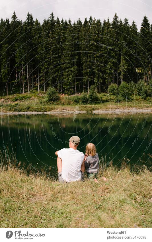 Vater und Tochter sitzen am Seeufer, Jochberg, Österreich sitzend sitzt Muße Miteinander Zusammen Bindung Gemeinschaft Verbundenheit Travel Ausfluege Ausflüge