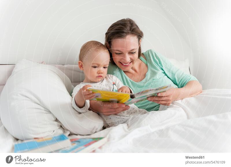 Mutter und Baby im Bett und lesen Bilderbuch Babies Babys Säuglinge Kind Kinder Bilderbücher Zuhause zu Hause daheim Lektüre Mami Mutti Mütter Mama Betten