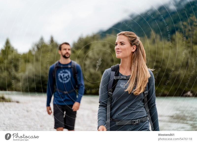 Junges Paar auf einer Wanderung am Flussufer, Vorderriss, Bayern, Deutschland Touristen Rucksäcke gehend geht geniessen Genuss zufrieden Muße Miteinander