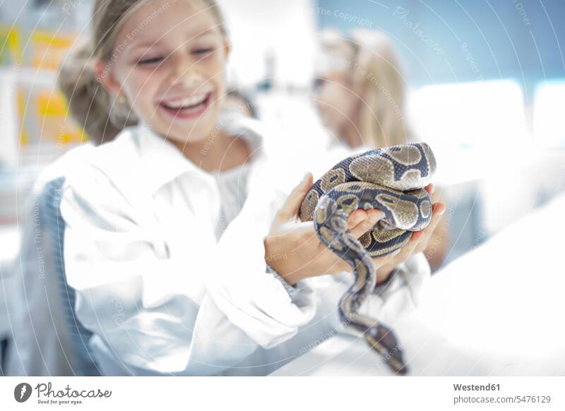 Glückliches Schulmädchen im naturwissenschaftlichen Unterricht hält Schlange halten Schülerin Naturwissenschaftskurs glücklich Schule Reptil Tier Schulkind