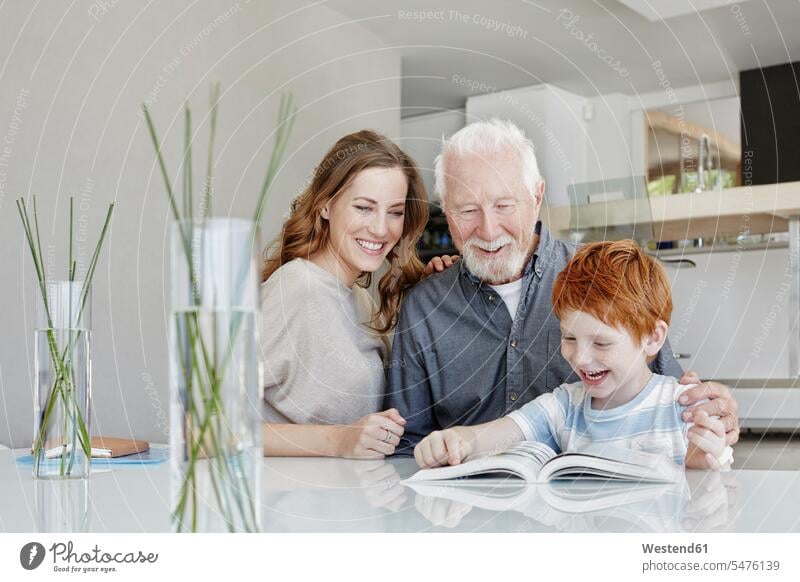 Glücklicher Grossvater, Mutter und Sohn beim Lesen eines Buches in einer Villa Generation Bücher Tische Lektüre freuen Frohsinn Fröhlichkeit Heiterkeit