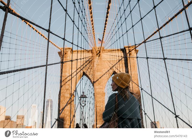 USA, New York, New York City, weiblicher Tourist auf Brooklyn Bridge im Morgenlicht entdecken Reisende Reisender morgendliches Licht Frau Frauen morgens früh