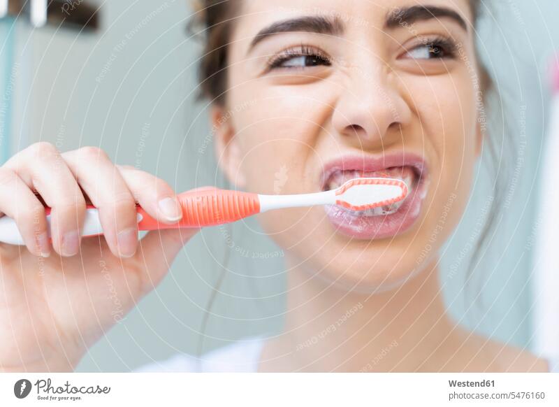 Frau beim Zähneputzen Zahnbürsten reinigen früh Frühe Morgen Farben Farbtoene Farbton Farbtöne weiss weiße weißer weißes daheim zu Hause alltäglich Bad drinnen