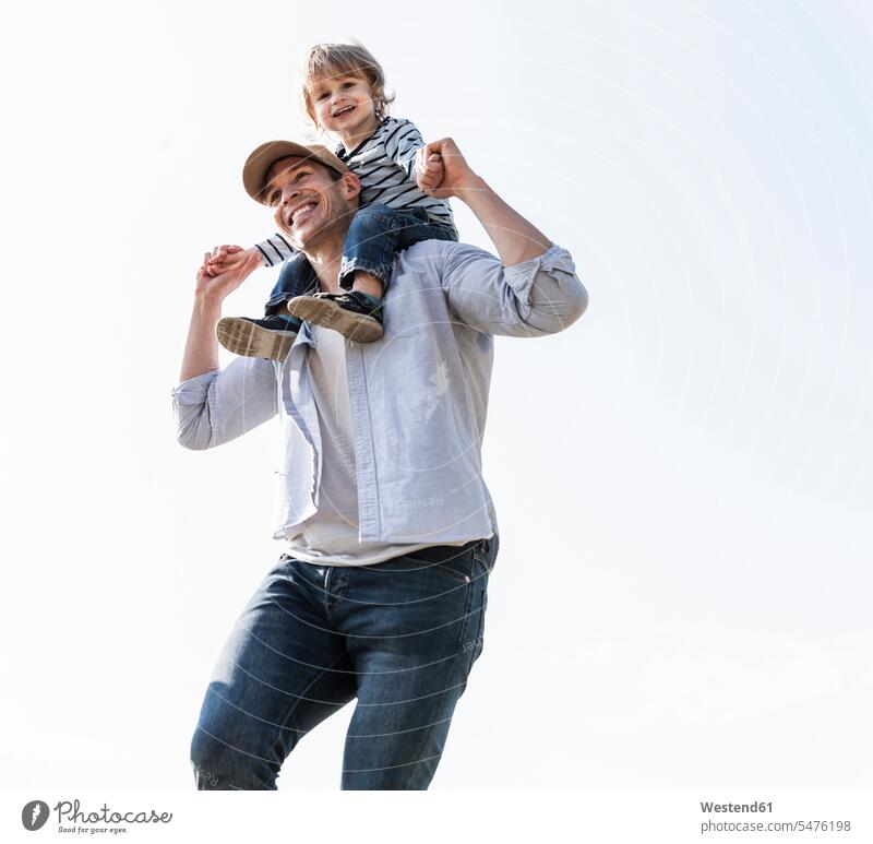 Glücklicher Vater, der seinen Sohn auf den Schultern trägt halten Zusammenhalt Verbundenheit Zusammengehörigkeit Bindung sich verstehen Gemeinschaft Unbeschwert