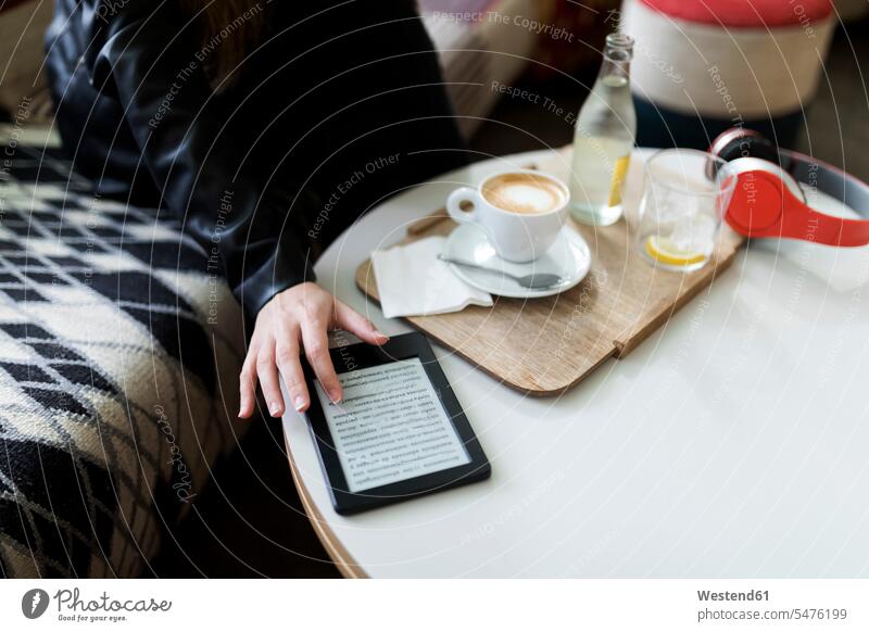 Nahaufnahme einer jungen Frau in einem Café, die ein E-Book benutzt weiblich Frauen eBook sitzen sitzend sitzt Cafe Kaffeehaus Bistro Cafes Cafés Kaffeehäuser
