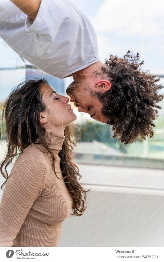 Küssendes Paar mit einem auf dem Kopf hängenden Partner gefühlvoll Emotionen Empfindung Empfindungen fühlen Gefühl Gefühle lieben einfuehlsam einfühlsam sanft
