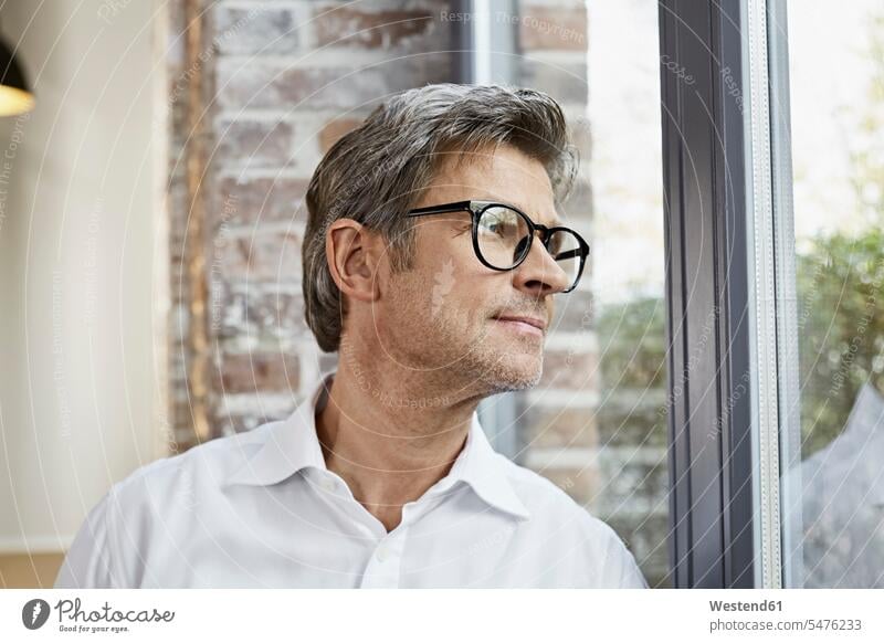 Älterer Geschäftsmann mit Brille, der aus dem Fenster schaut schauen sehend Businessmann Businessmänner Geschäftsmänner Brillen Geschäftsleute Geschäftspersonen